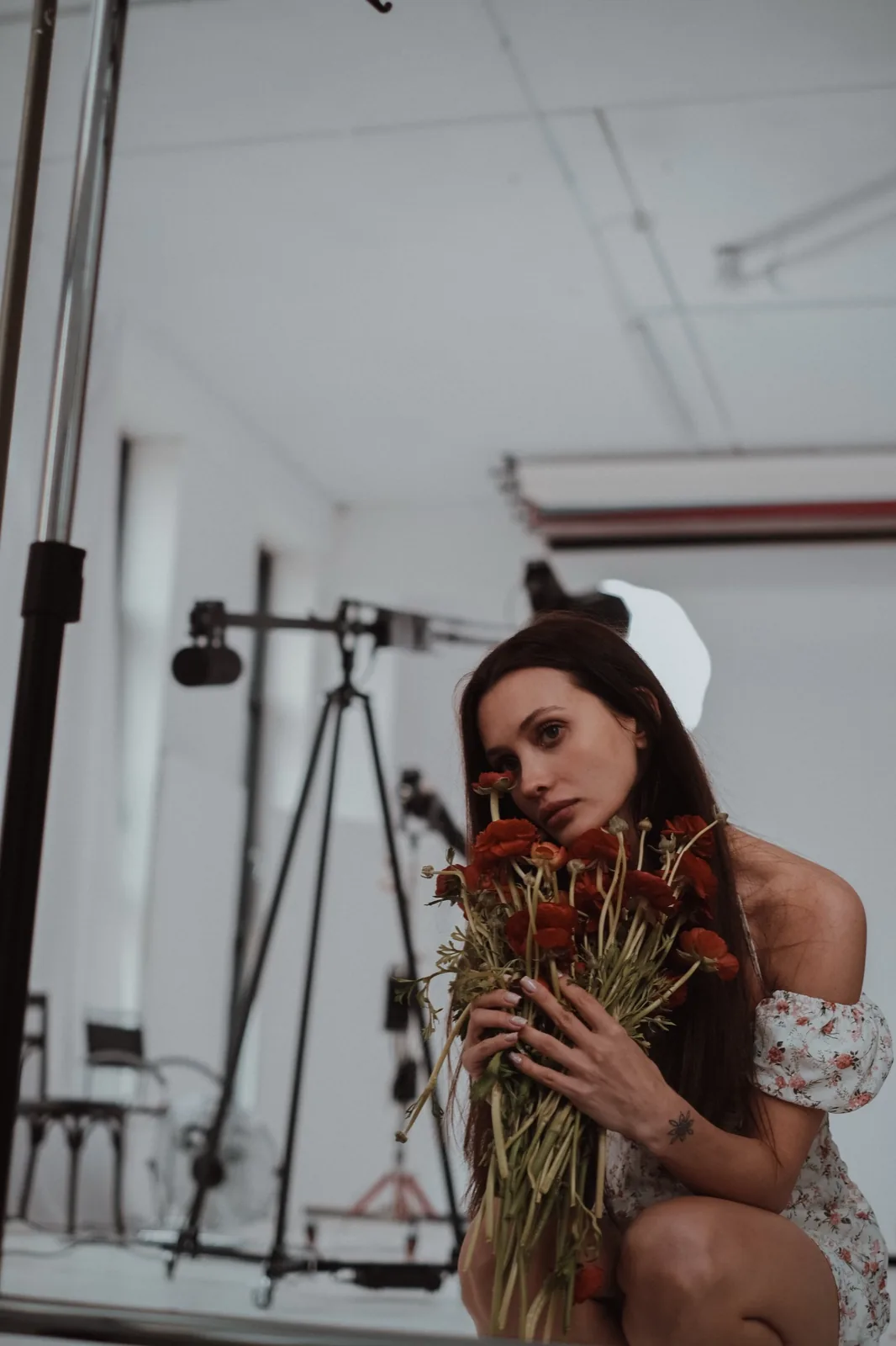 Nastia in her studio with a bouquet of poppies