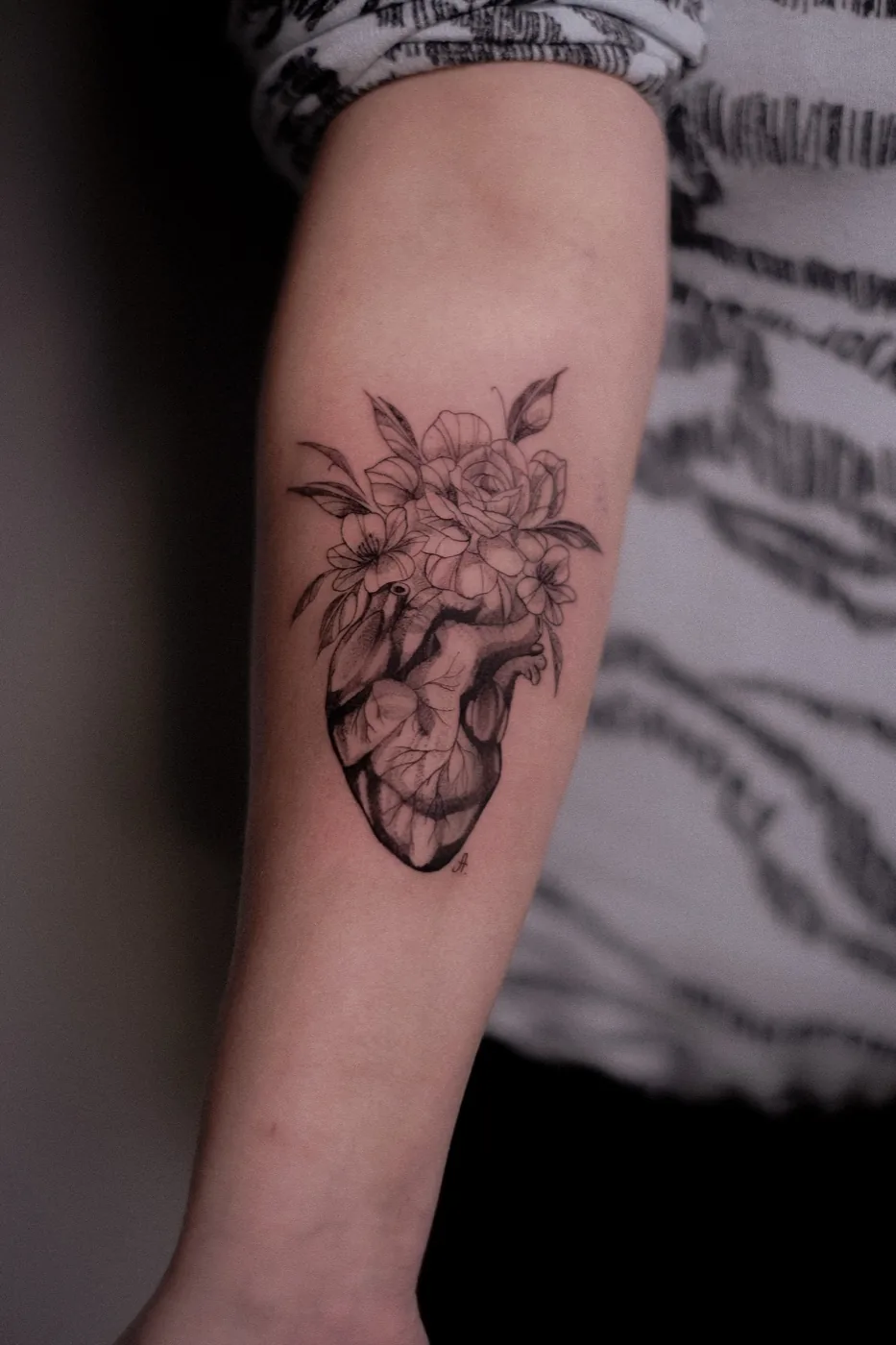 Anatomical heart with florals on forearm