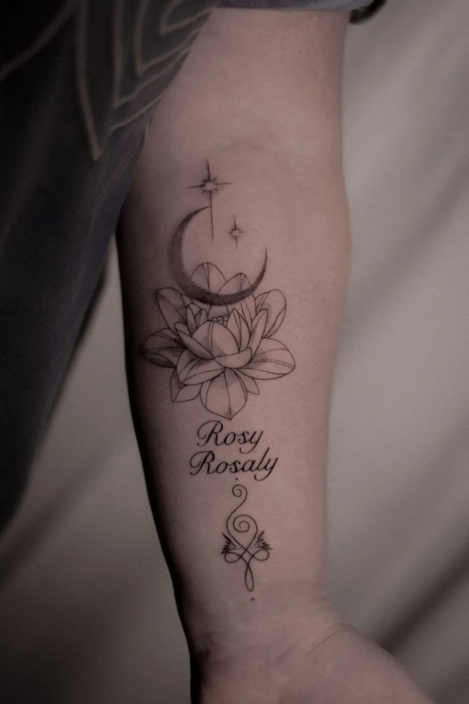 Moon, lotus and script on forearm